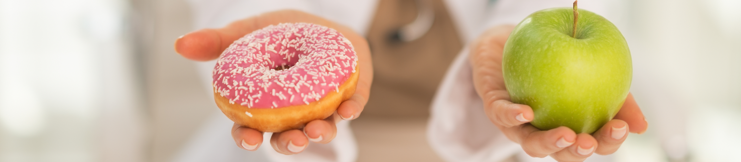 Крупен план на лекарка, която предлага избор между ябълка и поничка