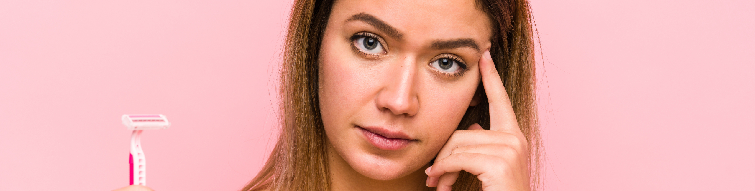 Млада жена, държаща бръснач и изглеждаща притеснена